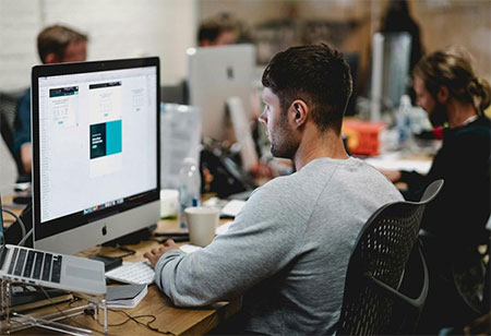A man in an office researching RFP automation on his computer