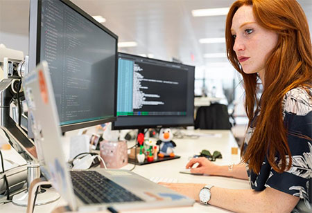 A woman in an office researching contact centers on her computer